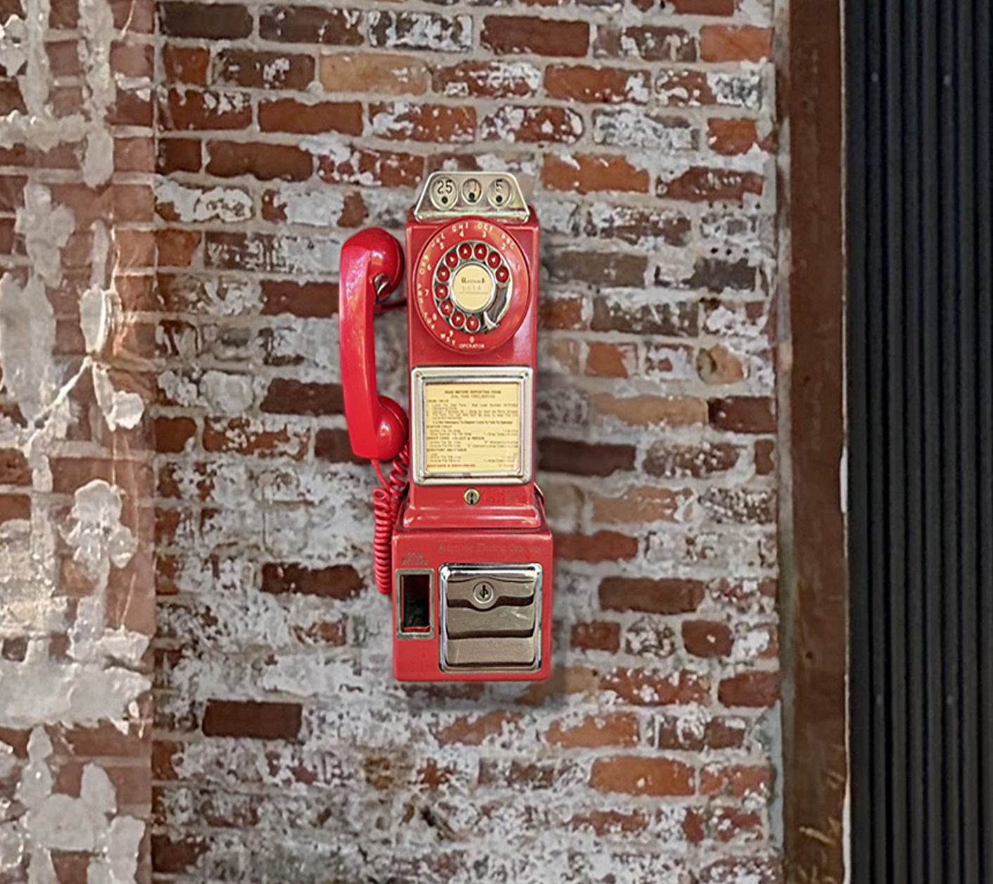 The red 1950s payphone of the Einstein Ghostphone on a whitewashed brick wall at the LOOP Art Center