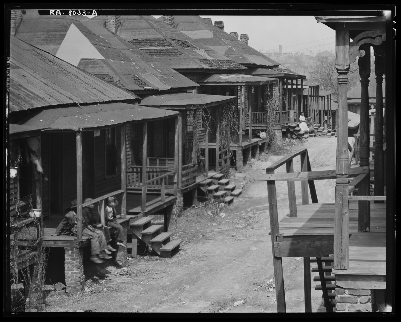A row of wood-frame houses with people on their porches. Walker Evans, Atlanta, Georgia (1936)
